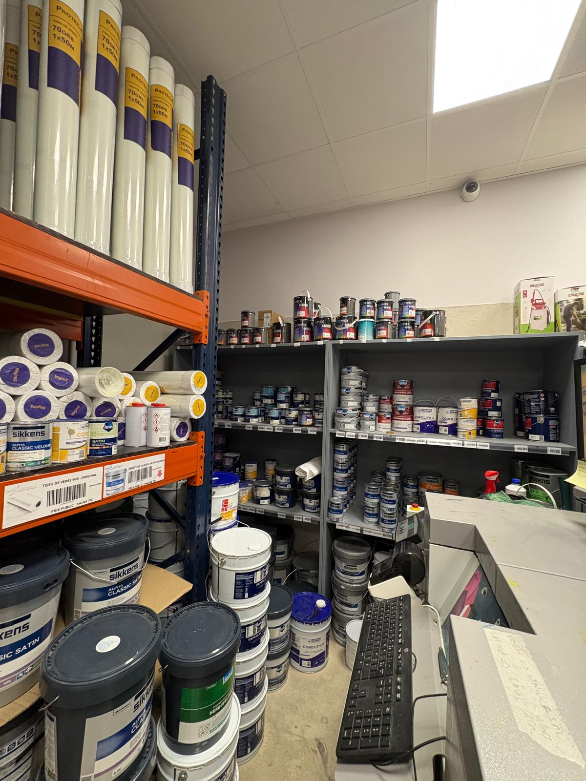 Pots de peinture et rouleaux dans le magasin